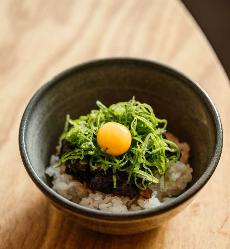Rice bowl with raw egg yolk on top.