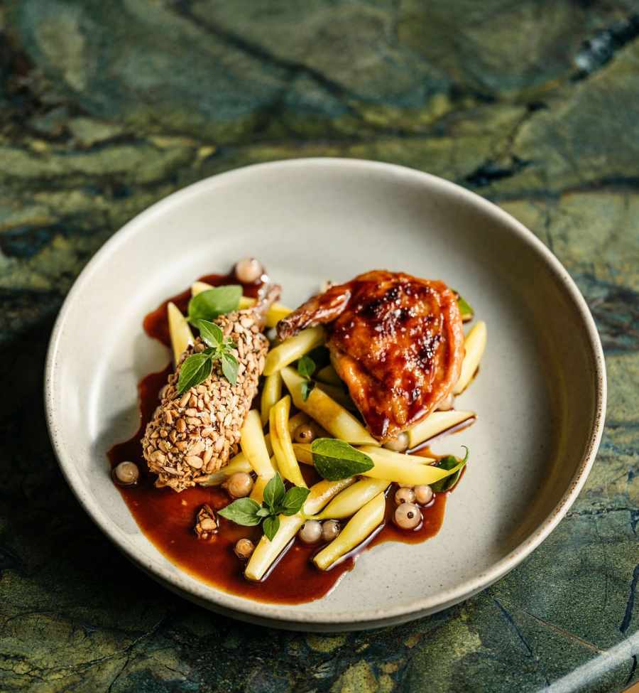 Grilled chicken on a bed of beans and sauce