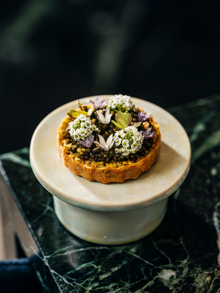 A savoury tart topped with caviar and edible flowers.